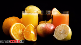 دانلود استوک فوتیج : لیوان آب پرتغال همراه با میوه Organic Juice And Fruits Rotating
