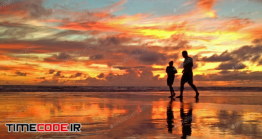 دانلود عکس استوک : ضد نور دو نفر در حال دویدن کنار ساحل Fire In The Sky