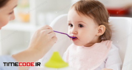 دانلود عکس استوک : غذا دادن به کودک Happy Mother Feeding Baby With Puree At Home