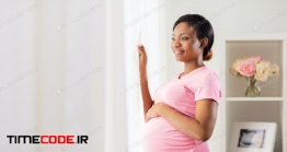 دانلود عکس استوک : زن باردار کنار پنجره Happy Pregnant Woman With Big Belly At Home