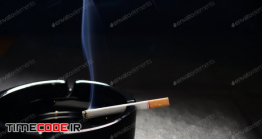 دانلود عکس استوک : سیگار در زیر سیگاری Lit Cigarette With Smoke Lying On An Empty Black Ashtray