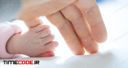 دانلود عکس استوک : نوزاد دست مادر را گرفته Newborn Baby Girl Holding Mother’s Little Finger