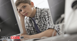 دانلود عکس دانش آموز پشت کامپیوتر در حال فکر کردن  A Boy In A School Room