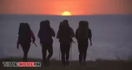 دانلود فوتیج ضد نور جهانگردان در غروب خورشید The Travelers Walking To The Sea Shore On Sunset Background
