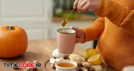 دانلود عکس زن در حال نوشیدن چای با عسل Woman Making Hot Tea With Honey