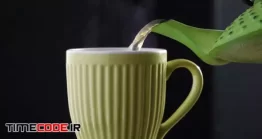 دانلود فوتیج ریختن چای داغ در لیوان همراه با بخار Closup Of Teapot And Mug With Steam Rising
