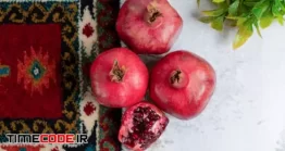 دانلود عکس انار روی قالیچه Top View Of Photo Of Fresh Sliced And Whole Pomegranate