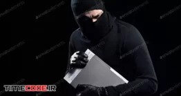 دانلود عکس هکر در حال سرقت اطلاعات سری  Burglar In Balaclava Holding Top Secret Documents