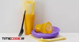 دانلود عکس لیوان و بشقاب یک بار مصرف Disposable Yellow Plastic Cups
