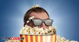 دانلود عکس مرد در میان انبوهی پاپ کورن Man In Glasses In A Bucket Of Popcorn Against Blue