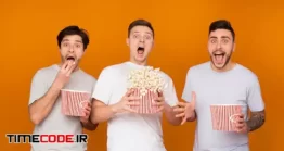 دانلود عکس پسرها با پاپ کورن در حال تماشای فیلم ترسناک Shocked Men Eating Popcorn And Watching Scary Movie