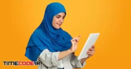 دانلود عکس زن مسلمان محجبه در حال یادداشت کردن Portrait Of Young Muslim Woman On Yellow Wall
