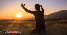 دانلود مردی با دستان بلند شده در غروب Man With Hands Raised In The Sunset